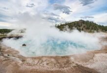A geothermal hot spring emitting steam in a natural landscape