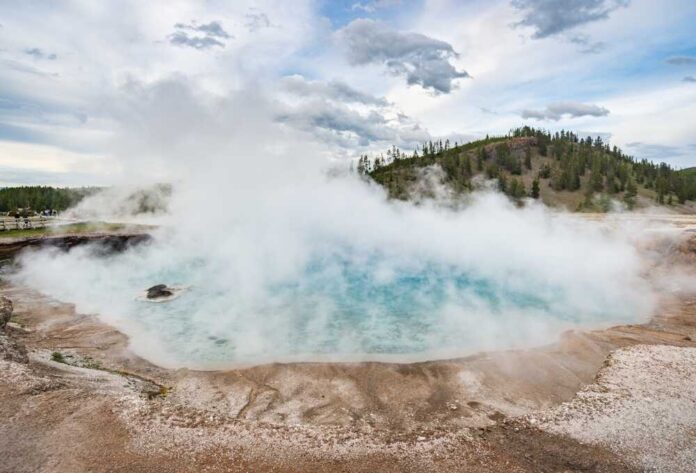 A geothermal hot spring emitting steam in a natural landscape