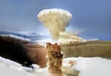 A large mushroom cloud rising into the sky from a nuclear explosion