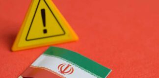 Iranian flag next to a caution sign on a red background