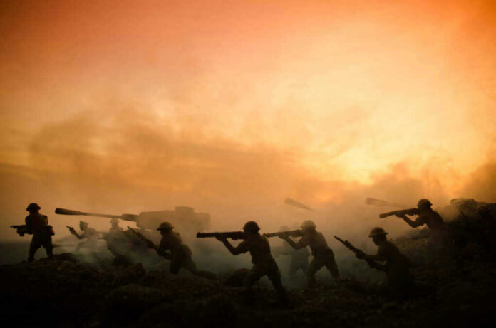 Silhouettes of soldiers advancing at sunset.