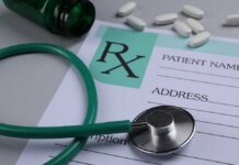 A prescription pad with a stethoscope and pills nearby