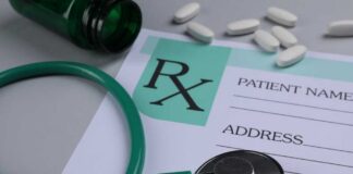 A prescription pad with a stethoscope and pills nearby