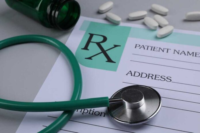 A prescription pad with a stethoscope and pills nearby