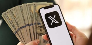 Person holding a smartphone displaying a logo with cash in the other hand