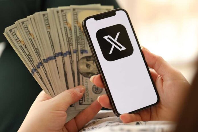 Person holding a smartphone displaying a logo with cash in the other hand