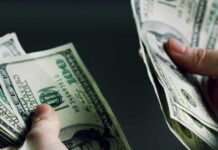 Hands holding and counting stacks of cash