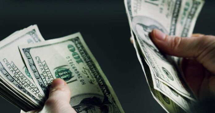 Hands holding and counting stacks of cash