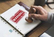 Hell Unleashed: Trump’s Final Warning? A hand applying a warning stamp on a document