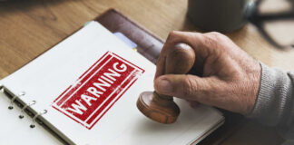 Hell Unleashed: Trump’s Final Warning? A hand applying a warning stamp on a document