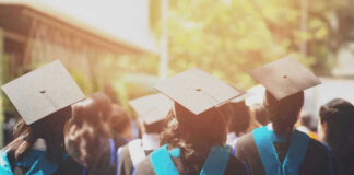 Graduates wearing caps and gowns in ceremonial procession.