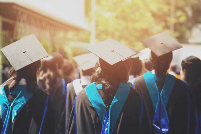 Graduates wearing caps and gowns in ceremonial procession.