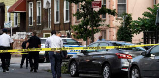 Police and crime scene tape on city street.