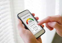 THIS Guts American Paychecks! Hand holding phone showing credit score app interface