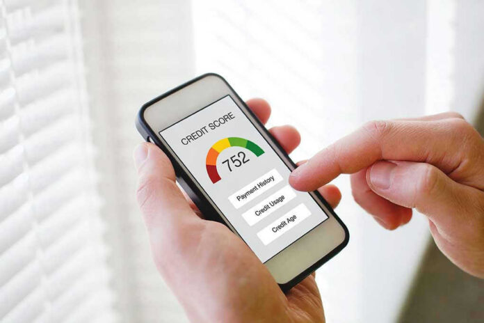 Hand holding phone showing credit score app interface