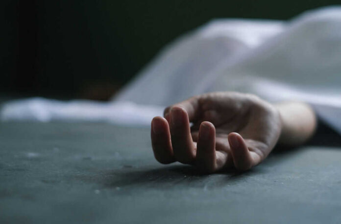 Dead persons hand lying on a gray surface