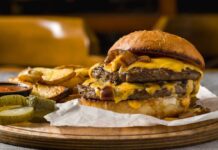Shocking Tragedy — Restaurant Under Fire A double cheeseburger with melted cheese and pickles served with potato wedges