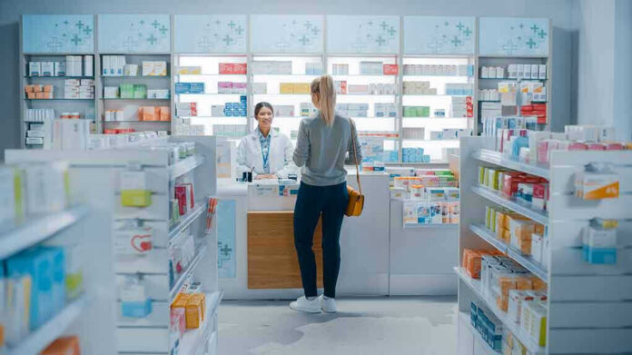Customer talking to pharmacist at a bright pharmacy.