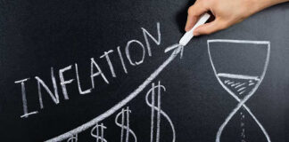 Chalkboard drawing of inflation with rising dollar symbols.