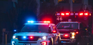 Domestic Call Shootout — Three Dead, Cop Down Police car and ambulance with flashing lights nighttime