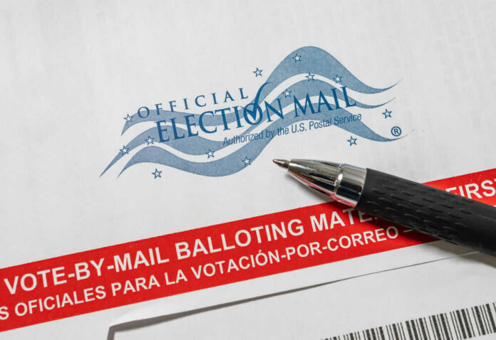 shutterstock_1787440103 Vote-by-mail envelope with pen on top.