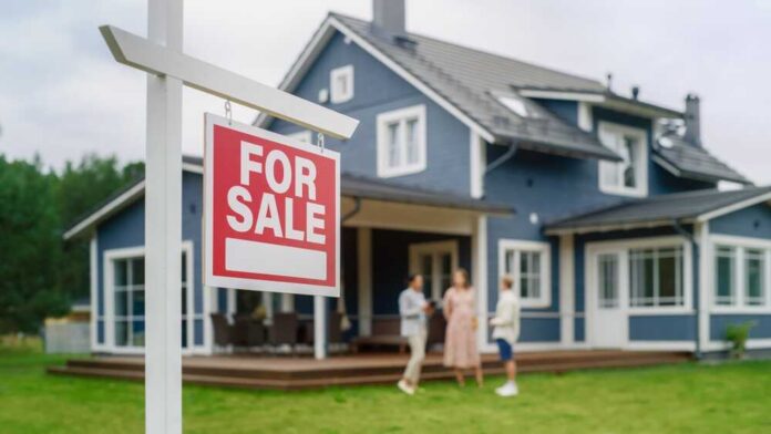 For sale sign in front of a house with potential buyers discussing