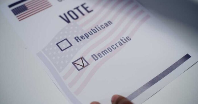 Close,Up,Of,Anonymous,Us,Citizen,Placing,Paper,Ballot,On Voting ballot with options for Republican and Democratic parties