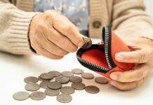 Americans’ Cushion Vanishes — Just 2.6% Elderly person placing a coin into a red coin purse