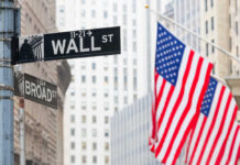 Street signs for Wall Street and Broad Street with American flags
