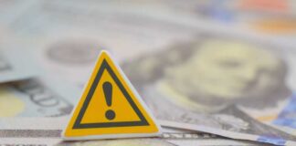 Billion-Dollar Slush Fund Backlash Erupts A warning sign placed on top of U.S. dollar bills