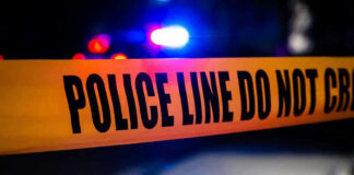 Drive-By Terror Shocks City Block Police tape with flashing lights in the background.