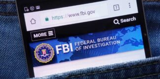 FBI Snags Basketball Player After $2.2M Vanishes Mobile phone displaying the FBI website in a denim pocket