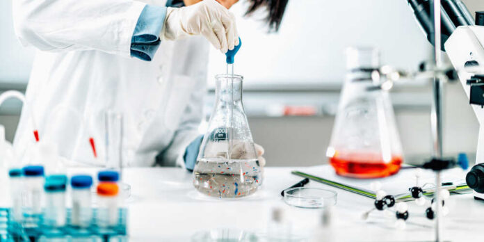 Microplastic,Pollution,Research.,Water,Quality,Researcher,Taking,Water,Samples,With Scientist in a lab using a pipette to transfer liquid into a flask