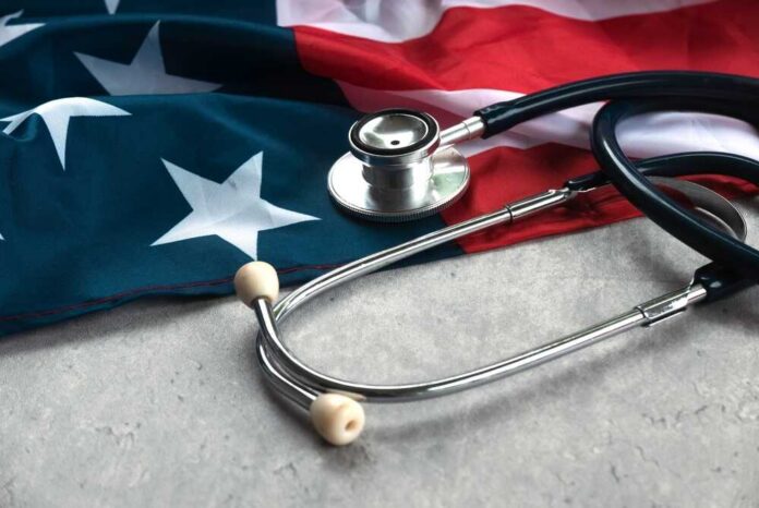 Usa,Flag,And,Stethoscope,Representing,Healthcare,And,Medical,Services,In A stethoscope resting on an American flag