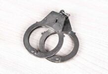 Suspect Captured – Deputy Marshal Killed A pair of metallic handcuffs resting on a light wooden surface