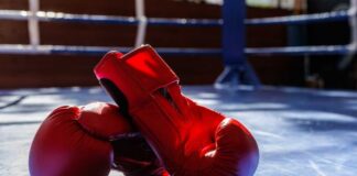 An empty boxing ring illuminated by bright lights in a sports arena