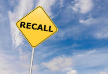 Exploding Product Triggers Costly Recall Yellow sign with RECALL text against blue sky.