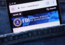 Court Bombshell Halts FBI Switch Mobile phone displaying the FBI website in a denim pocket
