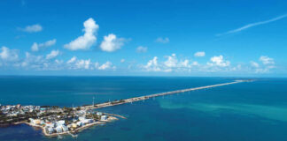 Aerial view of a coastal area with a long bridge extending over turquoise waters