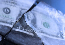 A dollar bill partially encased in ice