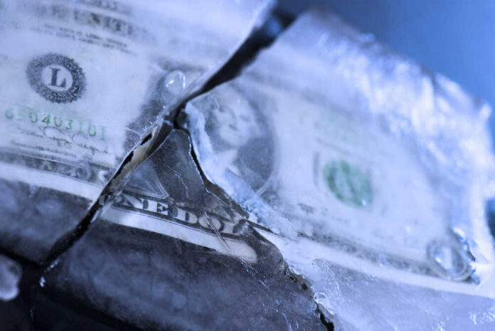 One,Dollar,Bill,Frozen,And,Broken,In,Ice,And,Money A dollar bill partially encased in ice