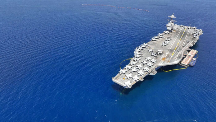 shutterstock_2354939171 Aircraft carrier on a vast blue ocean