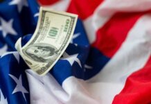 Free Money Chaos Hits Downtowns A hundred dollar bill resting on an American flag