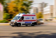 Ambulance van with flashing lights speeding through a city street
