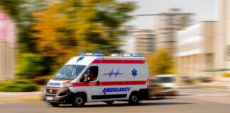 Ambulance van with flashing lights speeding through a city street