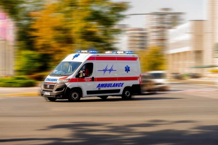Ambulance van with flashing lights speeding through a city street