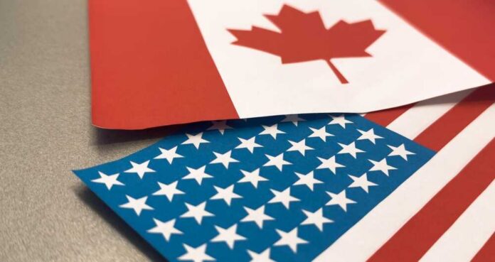 Canadian and American flags overlapping on a surface