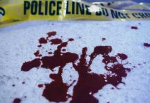 Sword Rampage Kills School Student Blood stains on a surface with police caution tape in the background