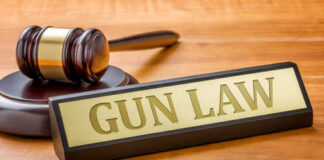 Ghost Tax Topples Gun Registry A gavel and a nameplate reading 'GUN LAW' on a wooden surface