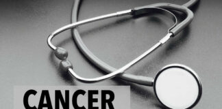 A stethoscope on a dark surface with the word 'CANCER' prominently displayed